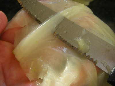 Trim the hard ribbed edge from the cabbage leaf